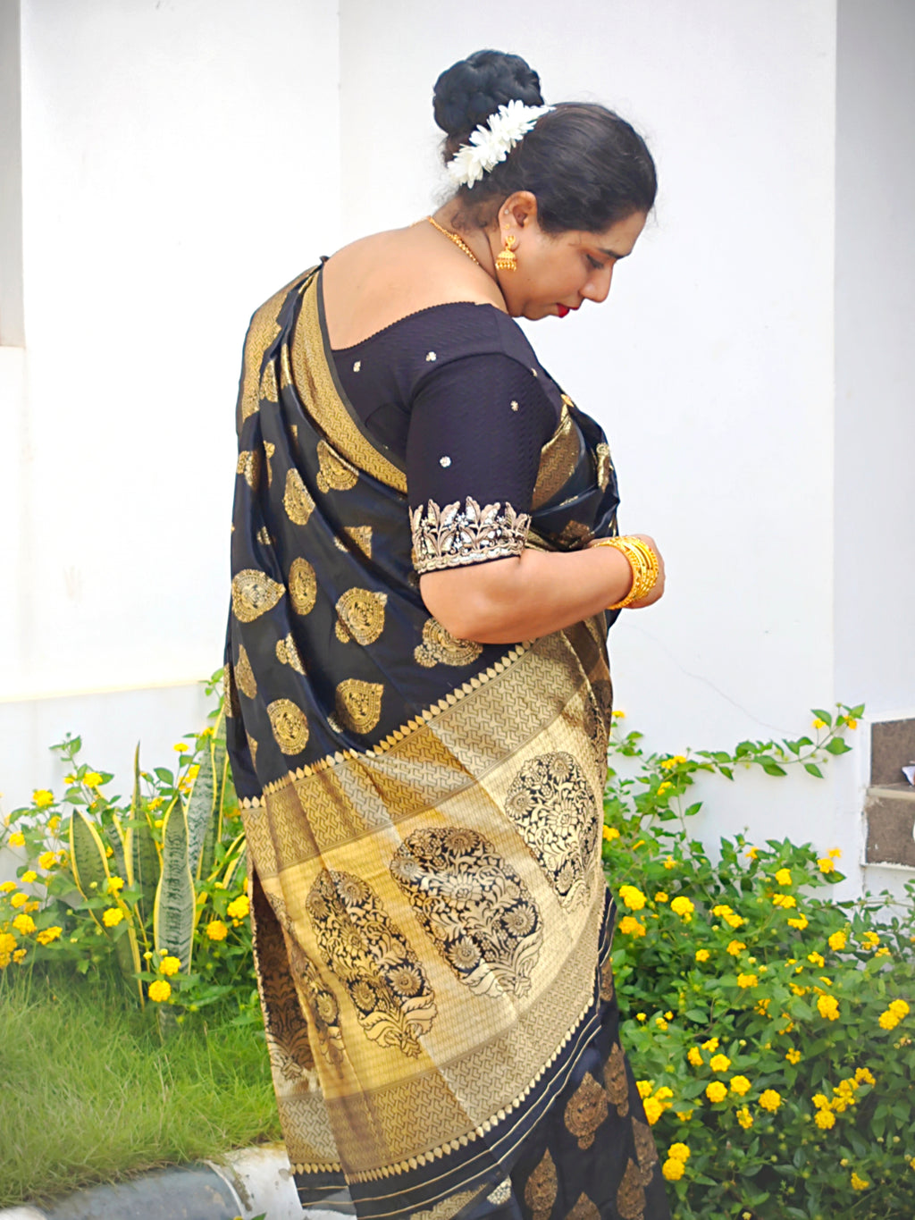 Close-up of the zari woven pallu on a Black Banarasi Silk Saree featuring intricate floral paisley (mango) motifs by Vyra Fashion.
